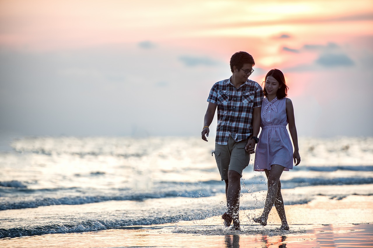 Couple walking along the coast: Summer Dating Guide for 2023